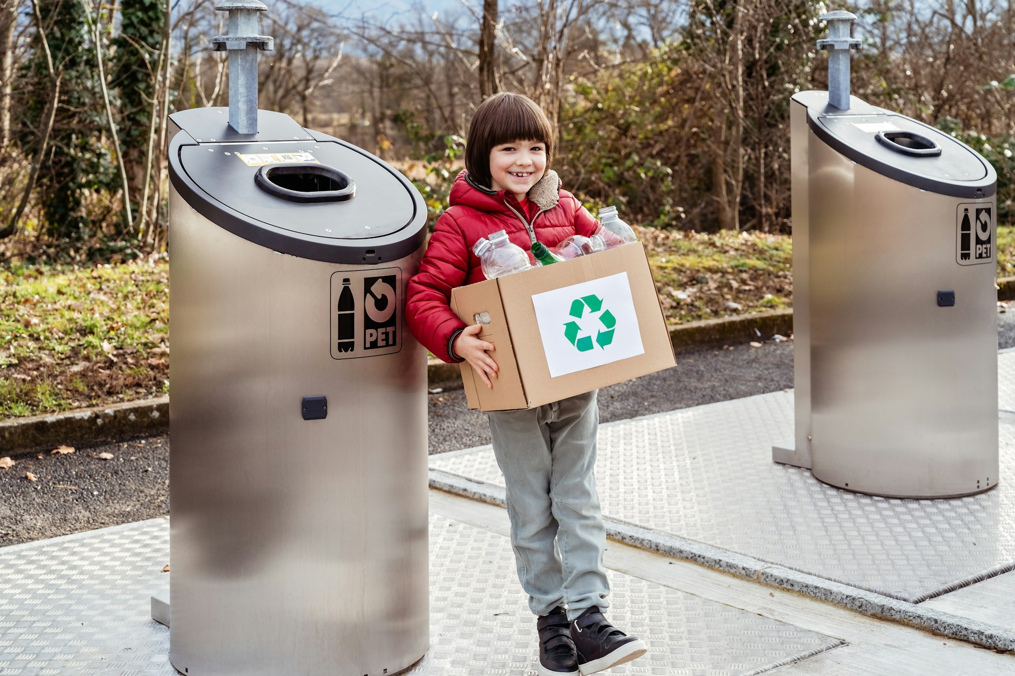 Child recycling plastic and glass waste at the recycling center