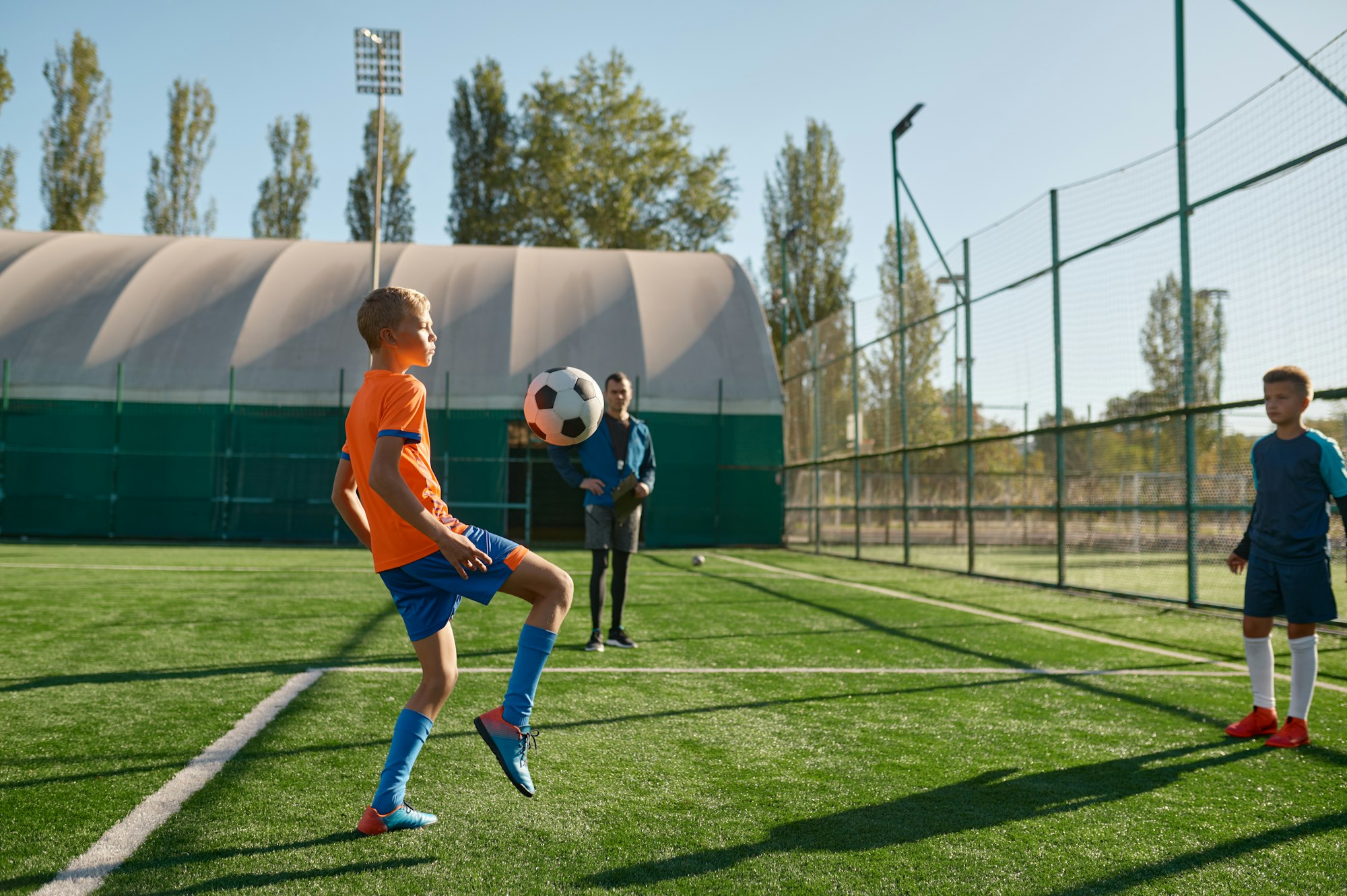 Young boys playing football soccer match at training camp for kids